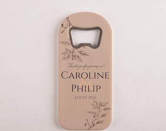 Può includere: Un apribottiglie marrone chiaro con un motivo floreale e il testo "Thank you for joining us! Caroline & Philip 23 July 2022".