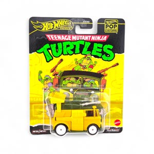 Könnte beinhalten: Ein gelber Hot Wheels Spielzeug-LKW mit den Teenage Mutant Ninja Turtles. Die Verpackung ist schwarz und gelb mit den Hot Wheels- und Pop Culture-Logos. Der LKW hat weiße Räder und ein grünes Dach.