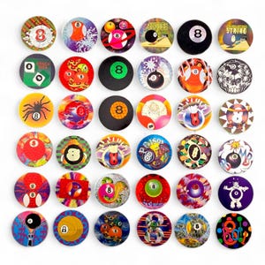 May include: A selection of vibrant, circular, retro-style billiard ball designs. Each design incorporates the number 8, alongside diverse graphics like spiders, skulls, and planets. The designs are printed on a glossy surface.