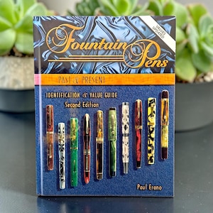 May include: A book titled "Fountain Pens Past & Present" with a blue cover and gold lettering. The cover features images of various fountain pens. The book is a guide for identification and value, second edition, by Paul Erano.