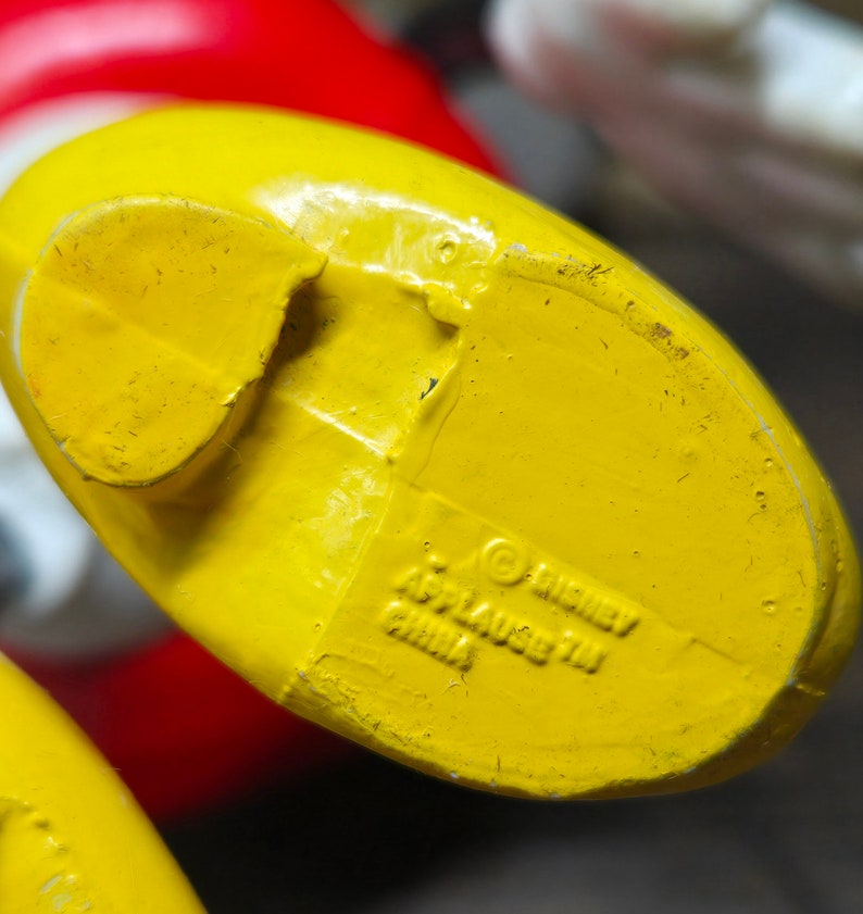 May include: Yellow plastic toy foot with a Disney copyright and "Applause 711 China" printed on the bottom.