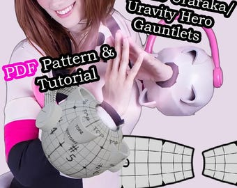 May include: A PDF pattern and tutorial for making a pair of cosplay gauntlets inspired by the character Ochako Uraraka from the anime My Hero Academia. The gauntlets are white with pink accents and feature a sphere-shaped design with a grid pattern.