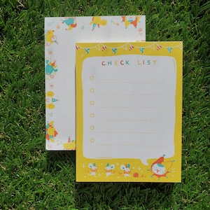 May include: A yellow checklist notepad with a white border and a whimsical illustration of mice and a cat. The notepad has a check list heading and a lined section for writing.