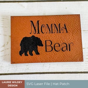 May include: A brown leather patch with the text "Momma Bear" and a black silhouette of a bear.