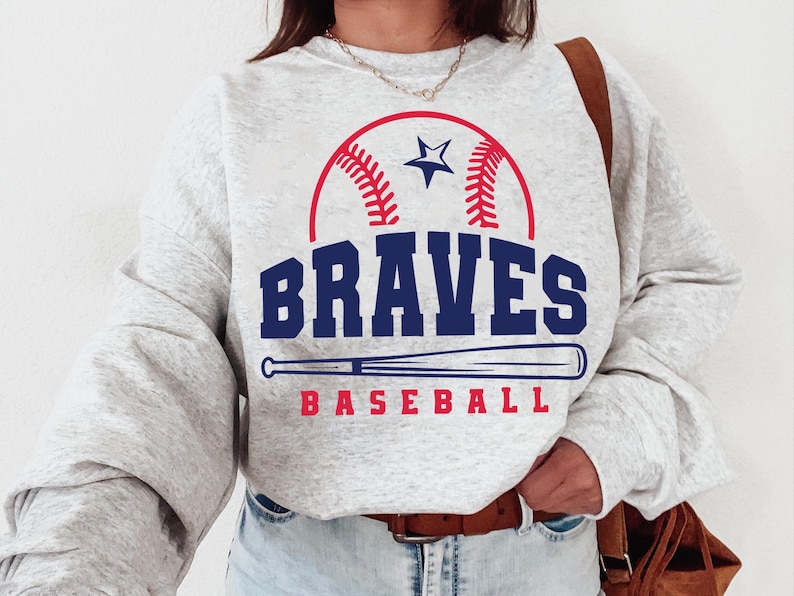 May include: Gray sweatshirt with a red, white, and blue baseball graphic and the text "BRAVES BASEBALL".