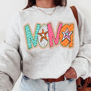 Peut inclure: Un sweat-shirt gris avec le mot "NOVA" imprimé en lettres colorées avec des étoiles et des motifs.