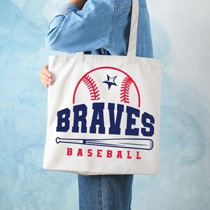 May include: White canvas tote bag with a blue and red baseball graphic and the text "BRAVES BASEBALL".