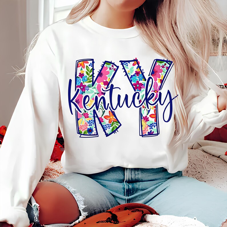 May include: White sweatshirt with a floral design of the letters "KY" and the word "Kentucky" underneath.
