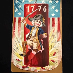 May include: Vintage patriotic postcard featuring a child in colonial attire holding a sword, emerging from a red cylinder with the year "1776." The background displays an American flag design with text that reads "This is a day of memory, 'Tis Freedom's Jubilee!"