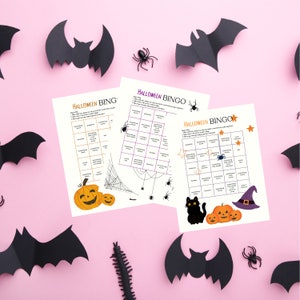 May include: Three printable Halloween Bingo cards with a spider web, black cat, and witch hat. The cards have a variety of Halloween-themed squares, including "something orange", "something spooky", and "something with a star".