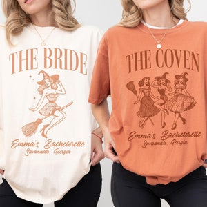 May include: An ivory t-shirt with brown text reading THE BRIDE and a witch graphic, and a yam-colored t-shirt with brown text reading THE COVEN and a graphic of three witches. Both shirts feature the text Emma's Bachelorette Savannah, Georgia.