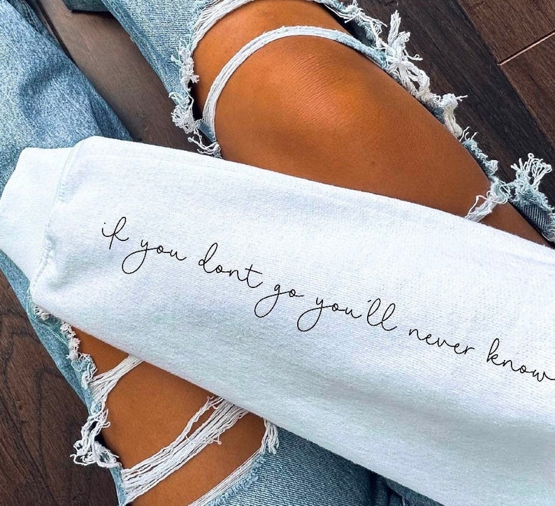 May include: A white sweatshirt with the text "if you don't go you'll never know" written in black cursive script.
