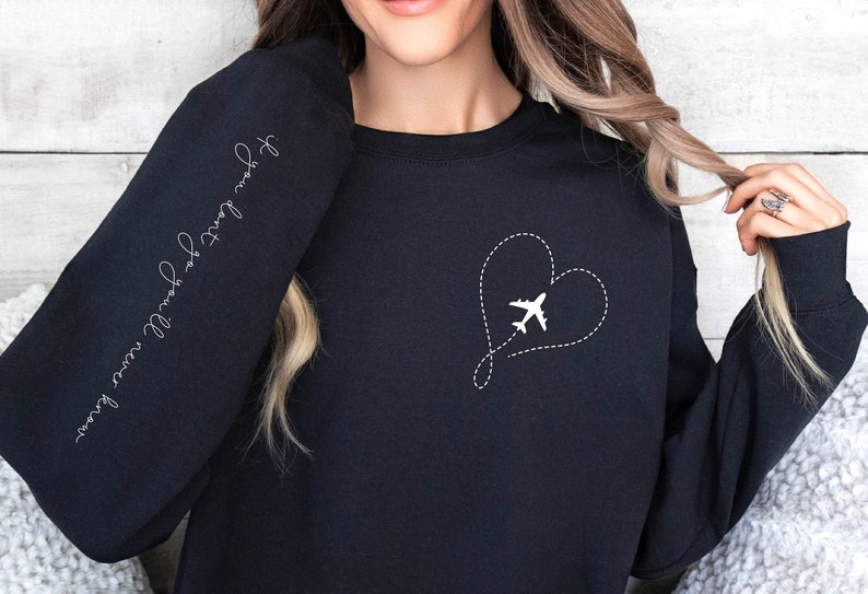 May include: Black sweatshirt with a white airplane flying inside a heart shape on the front. The text "Follow your own compass" is written on the left sleeve.