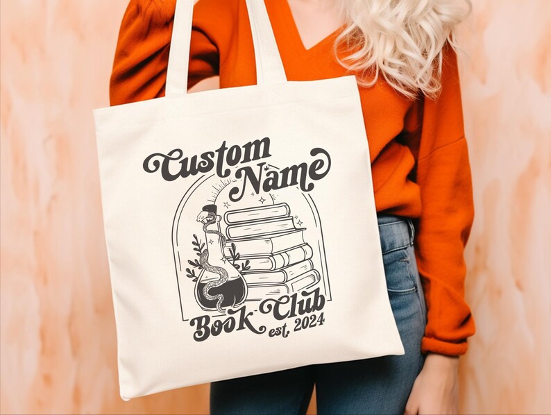 Puede incluir: Bolsa de tela blanca con texto negro y un gr&aacute;fico de una botella de poci&oacute;n con una serpiente y una pila de libros. El texto dice "Custom Name Book Club est. 2024".