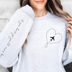 May include: Gray sweatshirt with a heart-shaped airplane design and the text "I love you more than words can say" on the sleeve.