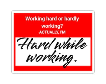Op de afbeelding: Een rechthoekige sticker met een rode achtergrond en witte tekst met de tekst "Working hard or hardly working? ACTUALLY, I'M Hard while working." De tekst is in een mix van lettertypen.