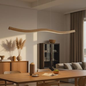 Könnte beinhalten: Eine moderne, wellenförmige Pendelleuchte aus Holz, die von der Decke abgehängt ist. Das Licht hat eine warme, natürliche Holzoberfläche und einen eingebauten LED-Lichtstreifen. Die Leuchte befindet sich über einem Esstisch aus Holz in einem gut beleuchteten Raum.