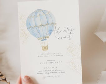 May include: A blue and gold hot air balloon with a white basket, surrounded by gold glitter, on a white background. The text "Adventure awaits" is written in cursive script. The invitation reads "Please join us for a Baby Shower Celebration honouring Lucy Thomson 25.05.202X four o'clock in the afternoon St James Chapel Manhattan Road rap name: 123 123 RI"
