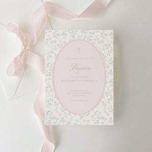 May include: A rectangular baptism invitation card featuring a light pink oval frame with a cross icon, surrounded by a delicate floral pattern of small pink roses and green leaves on a white background, accompanied by a soft pink silk ribbon.