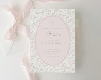 May include: A rectangular baptism invitation card featuring a light pink oval frame with a cross icon, surrounded by a delicate floral pattern of small pink roses and green leaves on a white background, accompanied by a soft pink silk ribbon.
