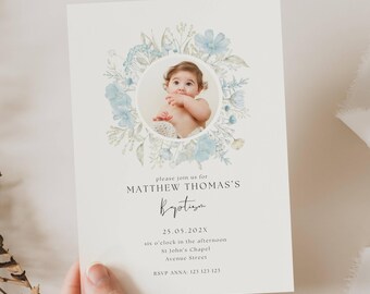 May include: A baptism invitation with a watercolor floral wreath in shades of blue and green surrounding a photo of a baby boy. The text reads "Please join us for Matthew Thomas's Baptism, 25.05.202X, six o'clock in the afternoon, St John's Chapel, Avenue Street, RSVP Anna 123 123 123".