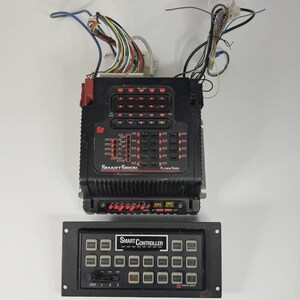 May include: A black Smart Siren Platinum Series control unit with multiple buttons and indicator lights, along with a separate Smart Controller panel. Wires extend from the top of the main unit.