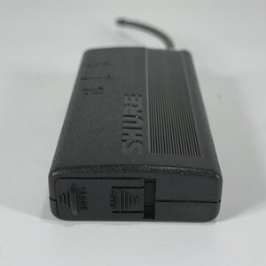 Puede incluir: Un receptor de micr&oacute;fono inal&aacute;mbrico Shure negro con una parte superior acanalada y el nombre de la marca impreso en el lateral. El receptor tiene un peque&ntilde;o cable negro adjunto y un interruptor con la etiqueta "OPEN".