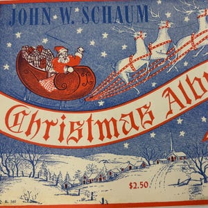 Può includere: Copertina di un album di Natale vintage con un design rosso e blu. Raffigura Babbo Natale su una slitta trainata da renne, con il titolo "Christmas Album" in uno striscione rosso. La copertina presenta un paesaggio invernale.