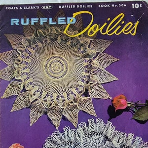 Op de afbeelding: Een vintage boekomslag met twee gehaakte doilies met gekrulde randen. De omslag is paars met de titel "RUFFLED Doilies" in gele letters. Het boek is getiteld "COATS & CLARK'S O.N.T. RUFFLED DOILIES BOOK No. 306 10¢".