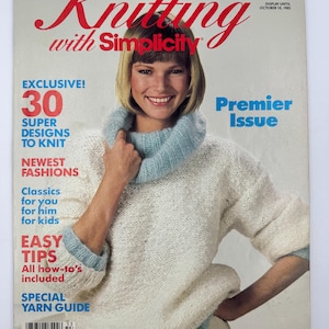 May include: A vintage Knitting with Simplicity magazine from Fall 1985, featuring a cover image of a person wearing a white knitted sweater with a light blue cowl neck and matching cuffs. The cover includes text such as Premier Issue and 30 Super Designs.