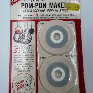 May include: Vintage Susan Bates Pom-Pon Maker set. The package features interlocking pop-in rings for making five different sizes of yarn pom-pons. The packaging is red and white with the text "Exclusive" and "Made in U.S.A."