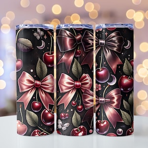 May include: Three black insulated tumblers with a repeating pattern of cherries, bows, butterflies, and moons. The bows and cherries are a deep red color, and the leaves are green. The background is black with white dots.