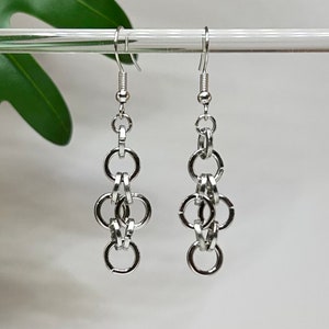 May include: Silver chain earrings with multiple interconnected rings hanging from a silver hook.