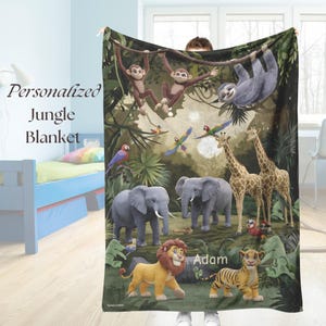 Könnte beinhalten: Eine personalisierte Dschungel-Decke mit Zeichentieren wie Affen, Elefanten und Giraffen. Die Decke hat einen grünen Hintergrund und den Text "Personalized Jungle Blanket" und einen Namen.
