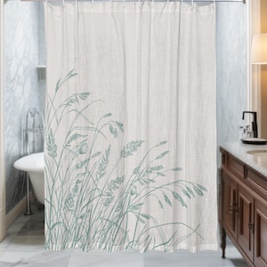 May include: Off-white shower curtain with a teal botanical design. The curtain features a detailed illustration of tall grasses and seed heads. The curtain is hanging in a bathroom with a white bathtub and a wooden vanity.