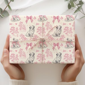 May include: A white gift wrap with a pink and gray repeating pattern of dogs, trees, and bows.
