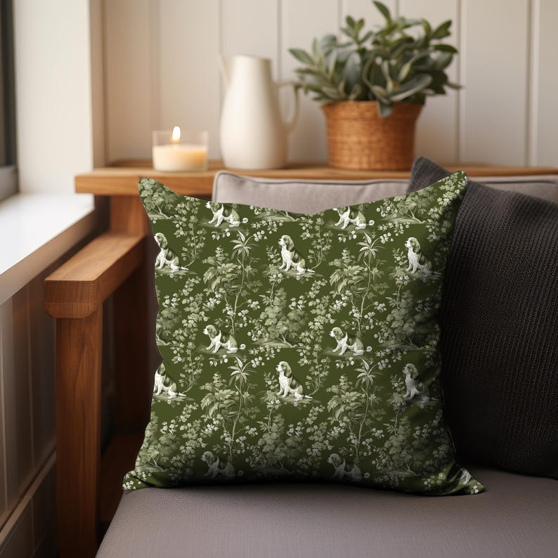 May include: A green throw pillow with a white and green pattern of dogs and foliage. The pillow is sitting on a couch.