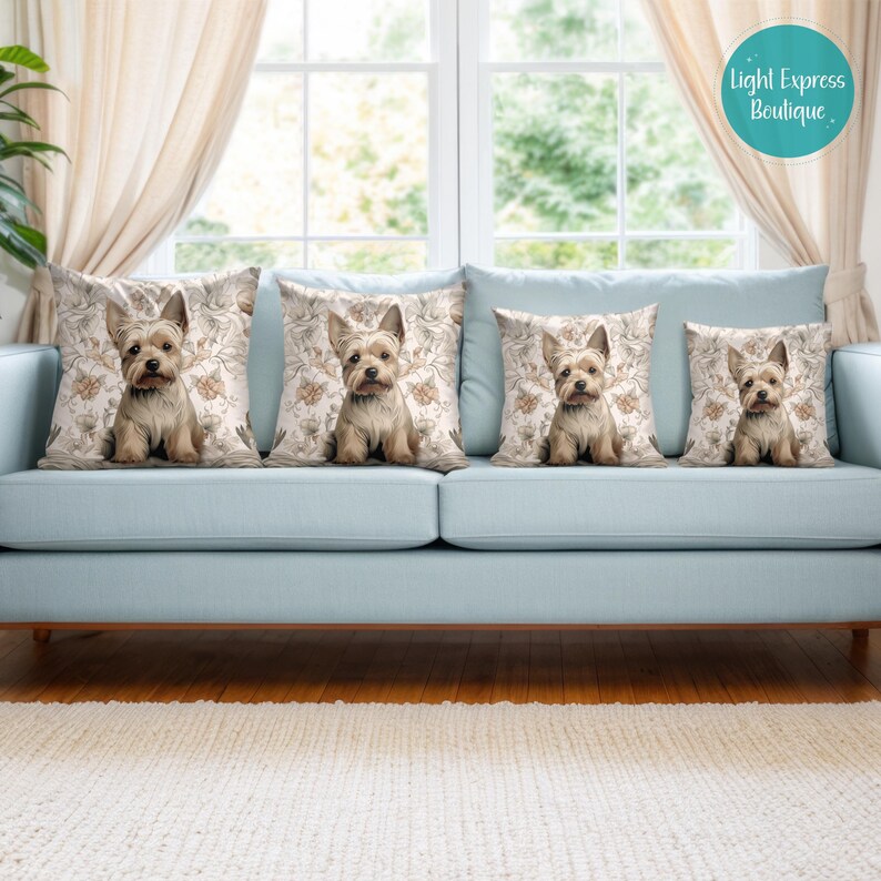 Puede incluir: Cuatro cojines con un patr&oacute;n floral y una ilustraci&oacute;n de un perro Yorkshire Terrier en cada coj&iacute;n. Los cojines est&aacute;n en un sof&aacute; azul claro frente a una ventana.