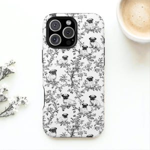 May include: A white phone case featuring a black and white toile pattern with pugs and floral elements. The case has a black camera module and a glossy finish. The design is repeated across the entire surface of the case.