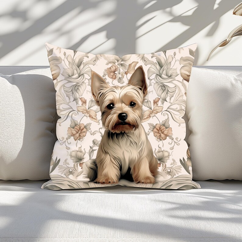 Puede incluir: Una almohada decorativa con fondo beige y un patr&oacute;n floral. Un peque&ntilde;o Yorkshire Terrier est&aacute; sentado en el centro de la almohada.