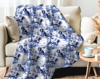 Könnte beinhalten: Eine weiße und blaue Decke mit einem sich wiederholenden Muster von Hunden in einem blauen und weißen Blumendesign.