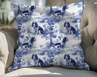 Könnte beinhalten: Ein weißes Kissen mit einem blauen und weißen Muster aus Hunden und Blumen. Die Hunde sind in einer Jagdszene und die Blumen in einem Blumenmuster.