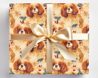 May include: A gold and white wrapping paper with a repeating pattern of Cavalier King Charles Spaniels, snowflakes, pine branches, and red berries.
