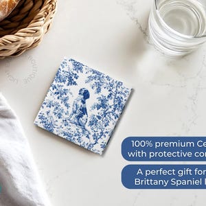Peut inclure: Sous-verre en c&eacute;ramique bleu et blanc avec un chien Brittany Spaniel dans un motif toile. Le dessous de verre a un dos en li&egrave;ge.