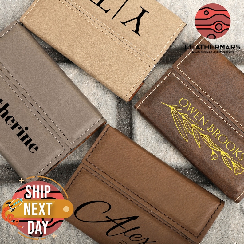 May include: Four personalized leather card holders in different colors. The card holders have different names and designs engraved on them. The card holders are made of high-quality leather and have a stitched edge.