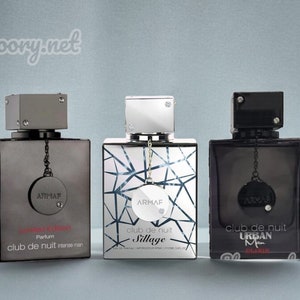 May include: Three silver and black glass bottles of perfume with a silver and black cap. The bottles are labeled "ARMAF club de nuit Sillage", "ARMAF club de nuit intense man Limited Edition", and "ARMAF club de nuit URBAN Man".