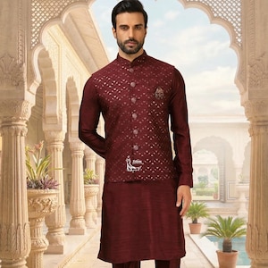 May include: A maroon three-piece suit featuring a patterned vest, long-sleeved shirt, and matching pants. The vest has a diamond pattern and button closure. The outfit is completed with white shoes. The background is a courtyard with columns and potted plants.