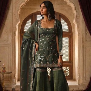 May include: An olive green ensemble featuring a long-sleeved top with intricate floral embroidery and a square neckline. The outfit includes wide-legged pants and a matching scarf, all adorned with delicate embellishments. The outfit is suitable for special occasions.