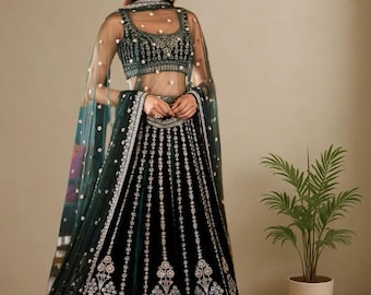 May include: A dark green ethnic outfit, featuring a heavily embroidered skirt and matching top. The outfit includes a sheer, dotted shawl. The text "ETHNIC OUTFITS" is displayed on a sign in the background.