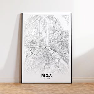 May include: Black and white line art map print of Riga, Latvia. The map shows the city streets and waterways. The city name and country are printed below the map.